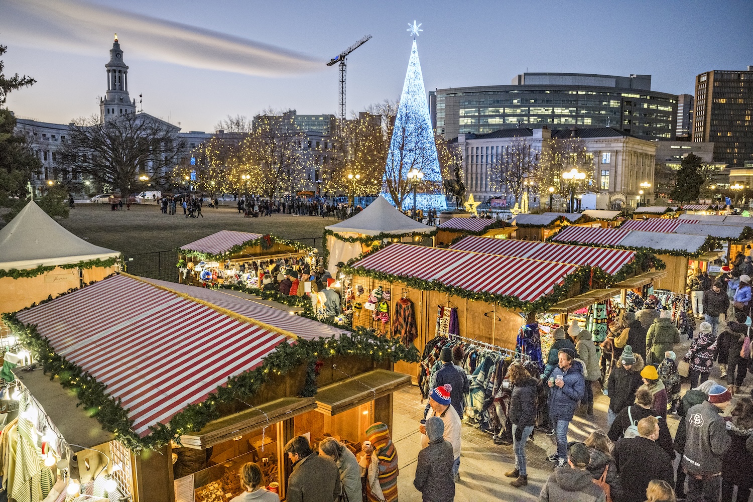 Holiday market in Denver with twinkling lights, artisan vendor booths, and families shopping during the festive season.