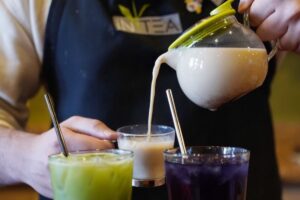 A person pouring milk into a glass