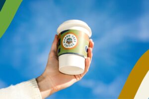 A hand holding a Mango Tree Coffee cup
