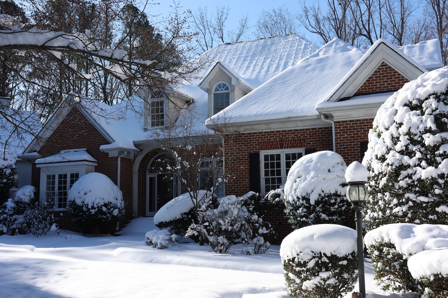 Snow Covered Brick House in Quiet Suburban Neighborhood